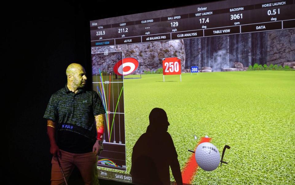 Alex Araujo looks over the shot data after a drive on the virtual driving range at Swing Center Indoor Golf in Modesto, Calif., Wednesday, August 23, 2023.
