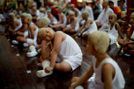 Boys with their heads smeared with thanaka bark wait to pray inside a temple after being shaved in preparation for an annual Poy Sang Long celebration, a traditional rite of passage for boys to be initiated as Buddhist novices, in Mae Hong Son, Thailand, April 2, 2018. REUTERS/Jorge Silva