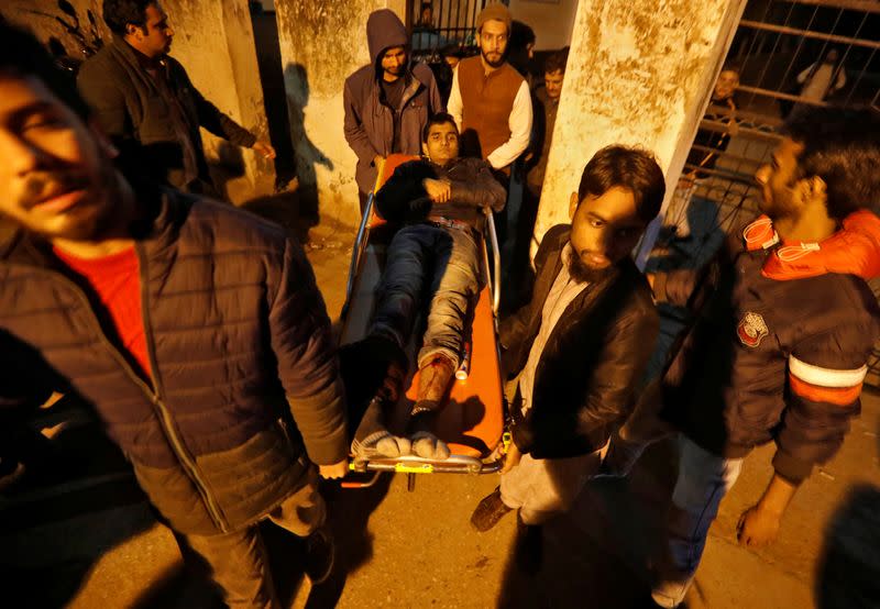A injured man is shifted to a hospital after he was wounded during a protest against a new citizenship law, in New Delhi