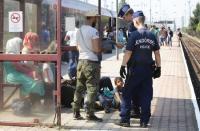 Hungarian police officers checks papers of a traveller as a train heading for Austria, with migrants on board, is stopped for checks at a border station in Hegyeshalom, Hungary, August 31, 2015. REUTERS/Heinz-Peter Bader