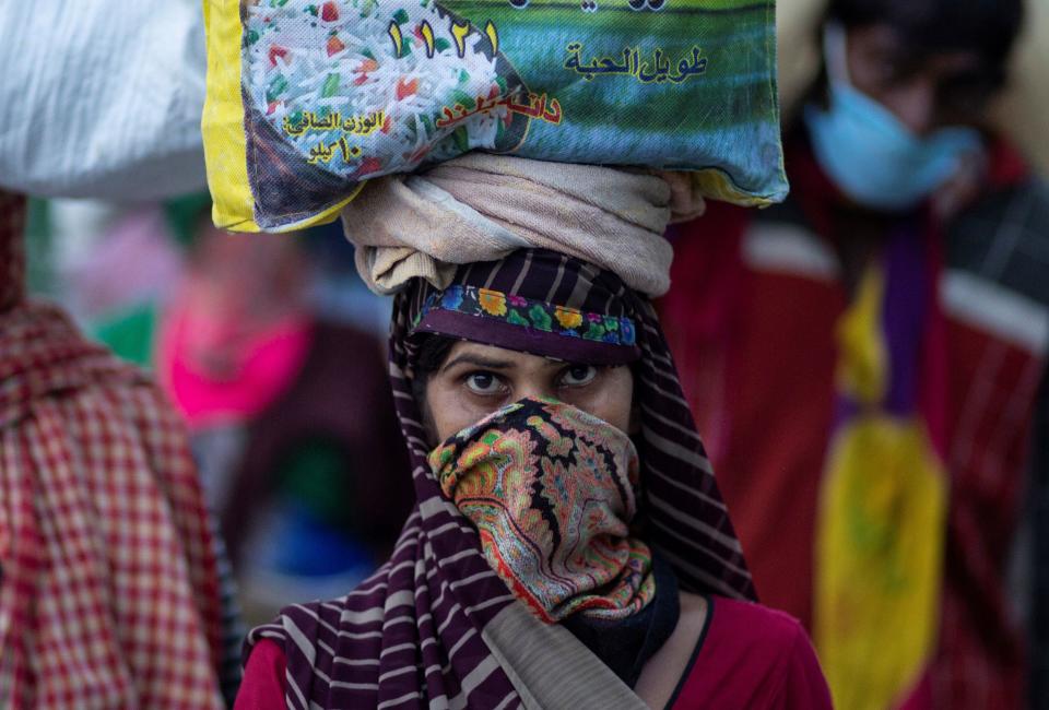 A migrant worker carries her belongings as she walks along a road to return to her village, during a 21-day nationwide lockdown to limit the spreading of coronavirus disease (COVID-19), in New Delhi, India, March 26, 2020. REUTERS/Danish Siddiqui