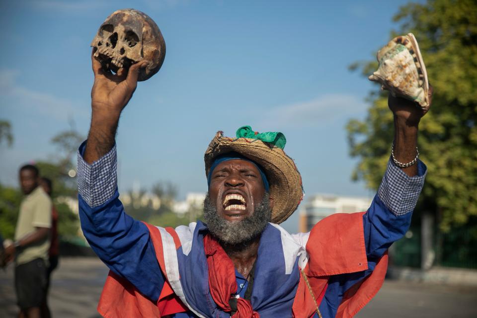 A protester holding up a skull and seashell shouts for the resignation of Haitian Prime Minister Ariel Henry in the street in the Champs de Mars area where the prime minister attended a ceremony marking the death anniversary of revolutionary leader Jean-Jacques Dessalines in Port-au-Prince, Haiti, Monday, Oct. 17, 2022. 