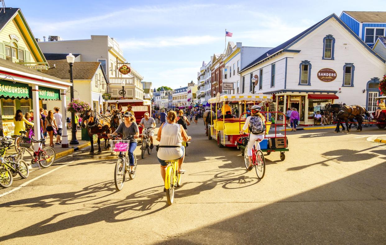 Mackinac Island, Michigan, August 8, 2016: Vacationers take on Market Street on Mackinac Island that is lined with shops and restaurants. No motorized vehicles are allowed on the island.