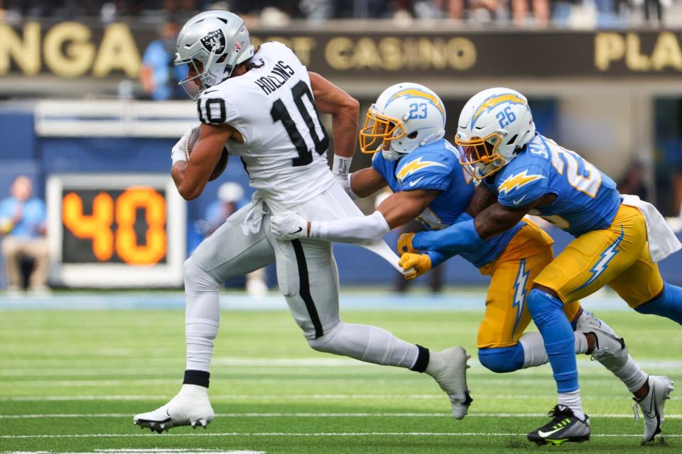 Chargers cornerbacks Bryce Callahan (23) and Asante Samuel Jr. (26) combine to tackle Raiders receiver Mack Hollins.