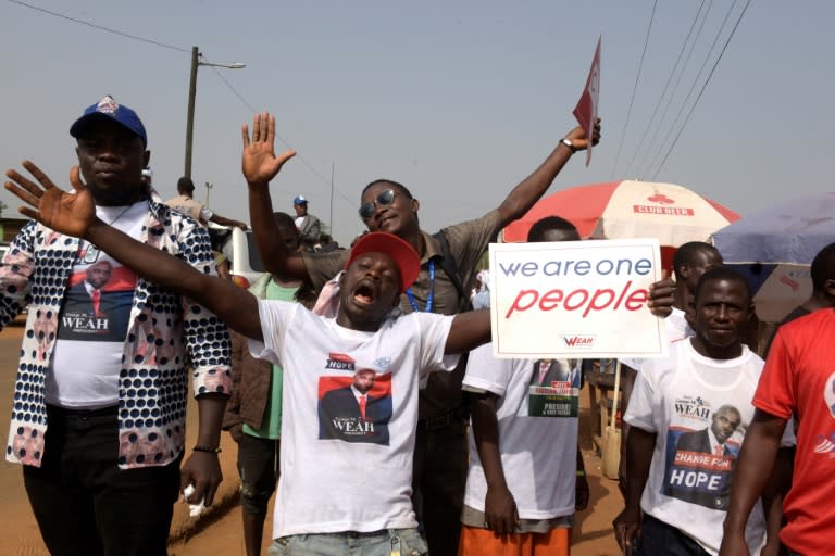 Supporters of Liberian presidential candidate George Weah dance near his home in Monrovia on December 23, 2017