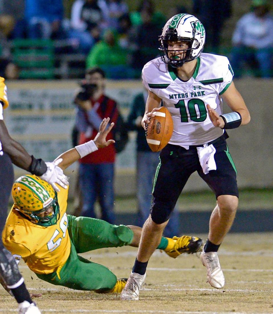 Myers Park Mustangs quarterback Drake Maye, right, side steps a Richmond Raiders defender as he looks to past a receiver during first half action on Friday, November 30, 2018. Myers Park led Richmond 27-7 at the half. Jeff Siner/jsiner@charlotteobserver.com