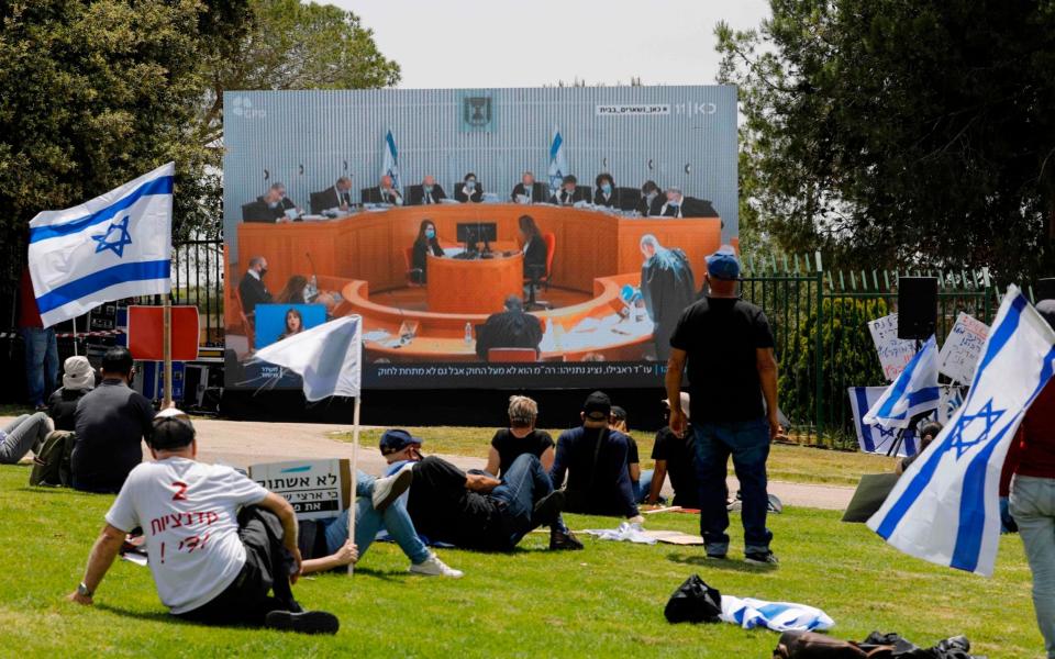 Israelis watch a live stream of Supreme Court deliberations - MENAHEM KAHANA/AFP