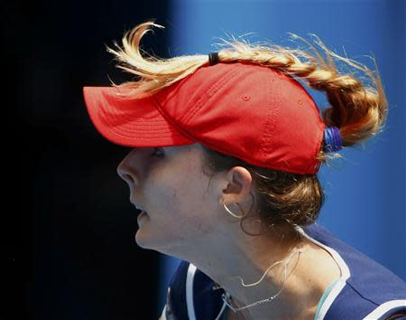 Alize Cornet of France's plait is seen on top of the cap she is wearing as she plays a shot to Maria Sharapova of Russia during their women's singles match at the Australian Open 2014 tennis tournament in Melbourne January 18, 2014. REUTERS/David Gray