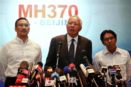 Malaysian Prime Minister Najib Razak (C) addresses reporters about the missing Malaysia Airlines flight MH370, as Transport Minister Hishammuddin Hussein (L) and Department of Civil Aviation's Director General Azharuddin Abdul Rahman (R) stand by him, at the Kuala Lumpur International Airport March 15, 2014. REUTERS/Damir Sagolj