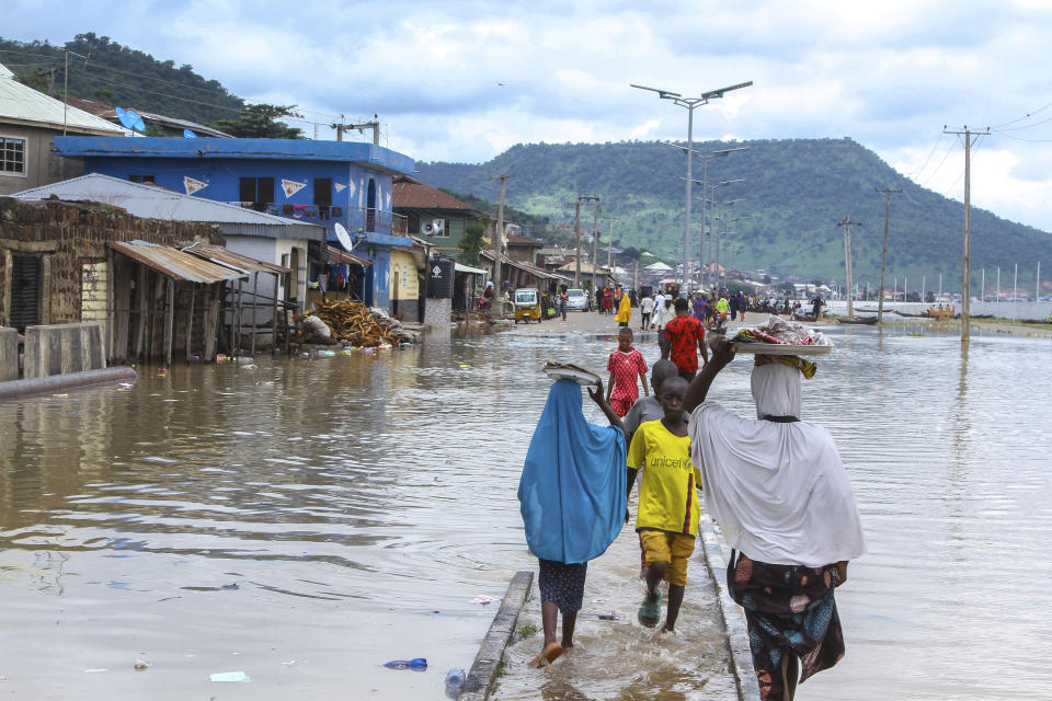 FILE- A view of stranded people due to floods following several days of downpours in Kogi Nigeria, Thursday, Oct. 6, 2022. Authorities in Nigeria say they have activated a national response plan for another round of deadly floods blamed mainly on climate change and infrastructure problems. The West African nation's National Emergency Management Agency said Thursday, July 6, 2023 it has begun to work based on dire forecasts by seeking air support for search and rescue missions while stockpiling relief materials. (AP Photo/Fatai Campbell, File)