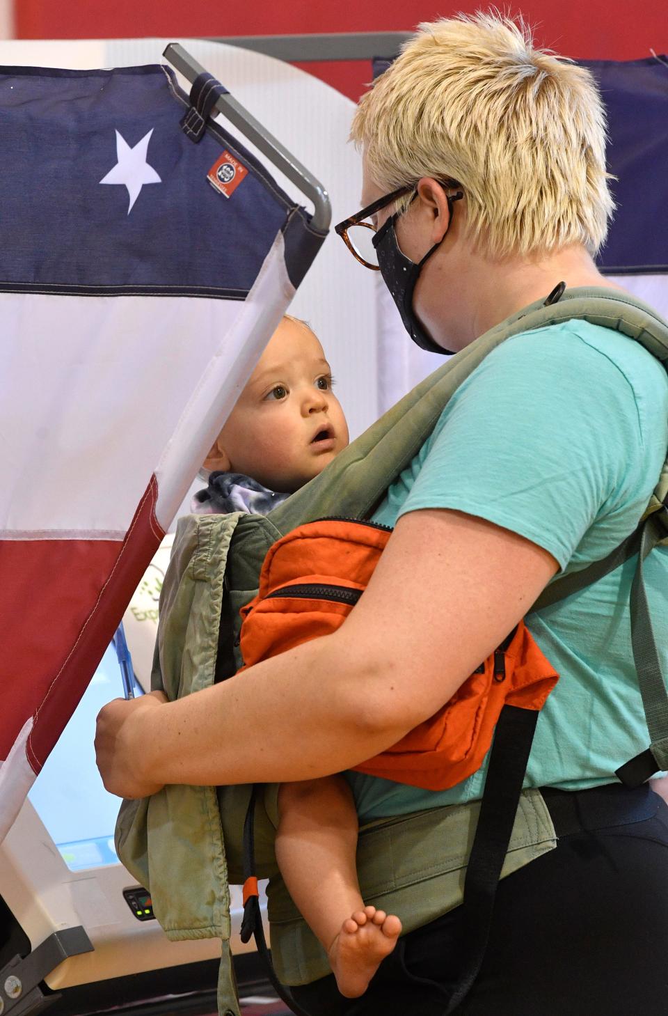 Emily Mimms carries her son Rufus into the voting booth as she casts her vote at Hadley Park on 28th Ave N in Nashville, Tenn. Thursday, Aug. 6, 2020 