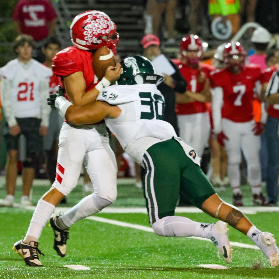 Manteca linebacker Tommy Perea delivers a big hit to the quarterback during a game between Manteca High School and Lodi High at The Grape Bowl in Lodi.