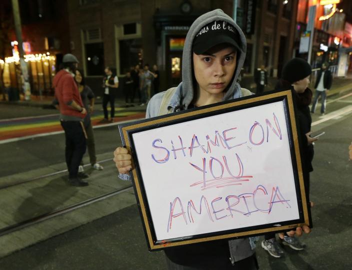 <p>Felomina Cervantes, of Seattle, holds a sign that reads “Shame on You America” as she takes part in a protest against President-elect Donald Trump, Wednesday, Nov. 9, 2016, in Seattle’s Capitol Hill neighborhood. (Photo: Ted S. Warren/AP) </p>