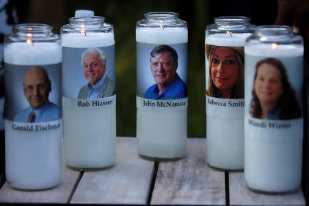 Candles representing the slain journalists of Capital Gazette sit on display during a candlelight vigil held near the Capital Gazette, the day after a gunman killed five people inside the newspaper's building in Annapolis, Maryland. REUTERS/Leah Millis