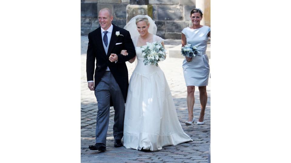 Zara Phillips and Mike Tindall smiling and linking arms on their wedding day