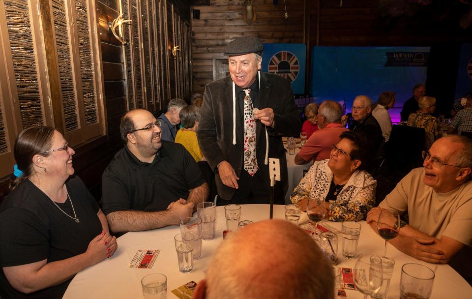 From left to right: April Green, Joe Ruffino, Johnny New York, Maria Elena Pace and Charles Pace share a laugh inside Camp Ticonderoga in Troy on Saturday, Sept. 30, 2023. John Smith, aka Johnny New York, performs close-up magic for the table during the Magic Soiree.