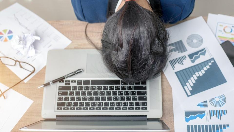 Una mujer parece haberse quedado dormida encima de un computador.