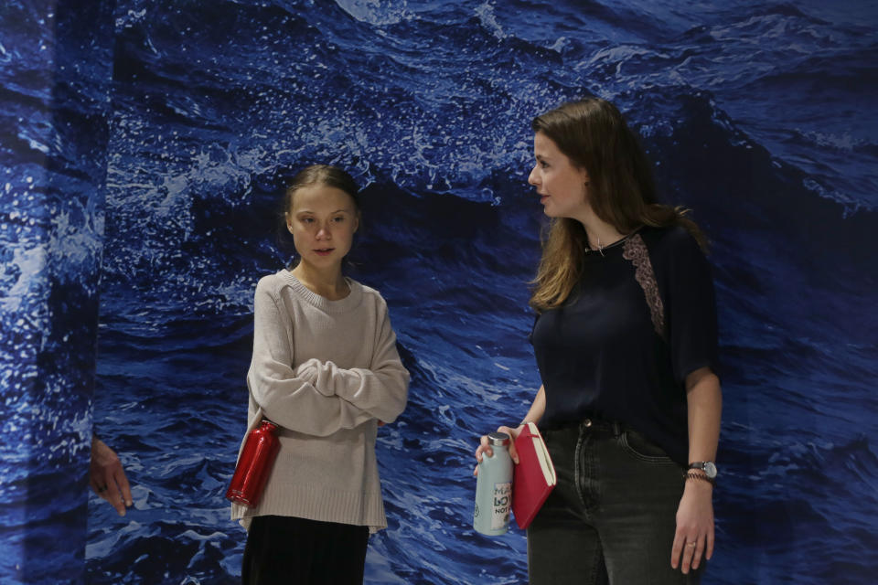 Youth climate activists Greta Thunberg, left, and Luisa Neubauer arrive for a meeting with leading climate scientists at the COP25 summit in Madrid, Spain, Tuesday, Dec. 10, 2019. Thunberg is in Madrid where a global U.N.-sponsored climate change conference is taking place. (AP Photo/Paul White)