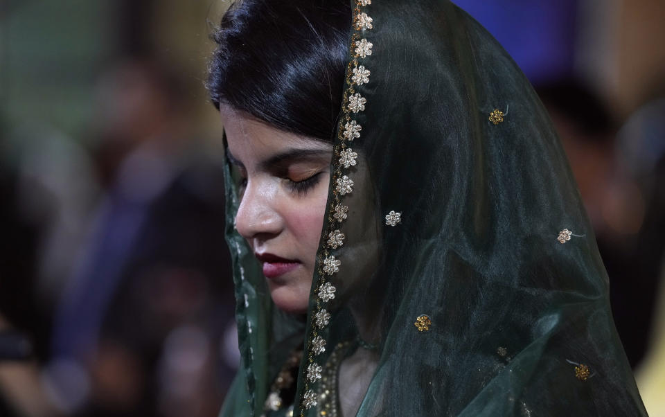 A woman attends midnight Christmas mass at St. Andrew's Church in Karachi, Pakistan, Sunday, Dec. 24, 2023. (AP Photo/Fareed Khan)