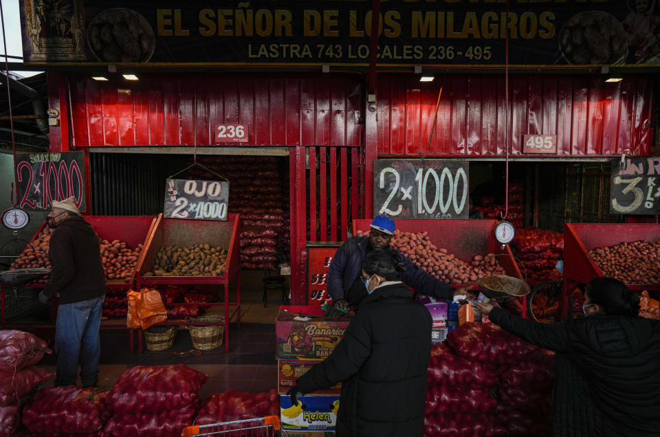 ARCHIVO - Comerciantes venden papas en el mercado de La Vega en Santiago de Chile, 13 de julio de 2022. (AP Foto/Esteban Felix, Archivo)