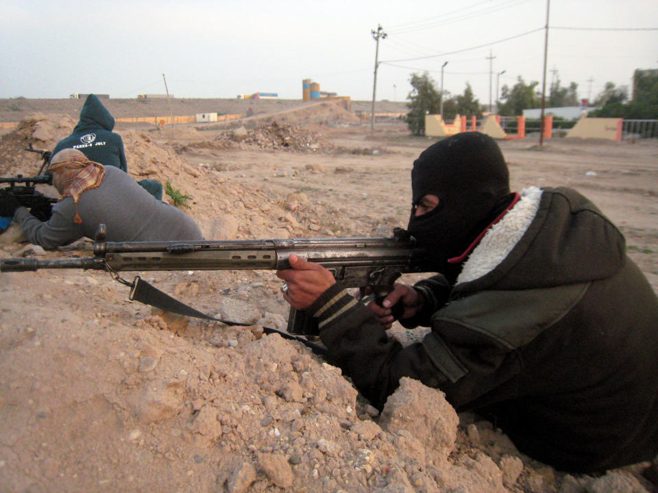 In this Thursday, Jan. 23, 2014 photo, gunmen take up combat positions in Fallujah, Iraq. Islamic militants controlling a mainly Sunni area west of Baghdad are so well-armed that they could occupy the capital, members of Iraq's al-Qaida branch - known as the Islamic State of Iraq and the Levant - have taken over parts of Ramadi, the capital of the largely Sunni western province of Anbar. (AP Photo)