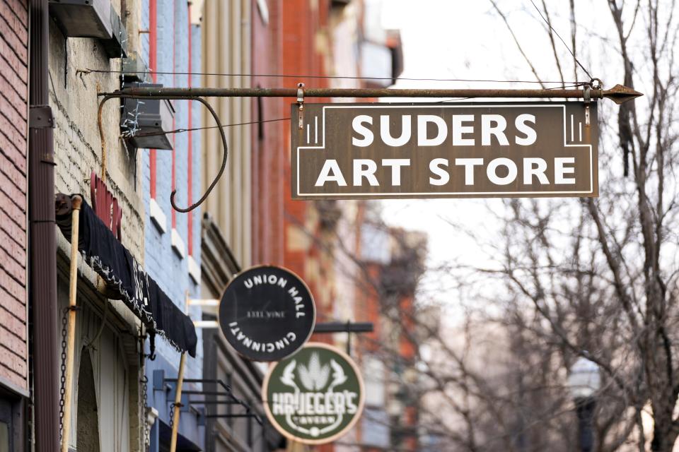 Signs outside point to Suder’s Art Store on Tuesday, Jan. 16, 2024, in Over-the-Rhine. The business is celebrating its centennial.