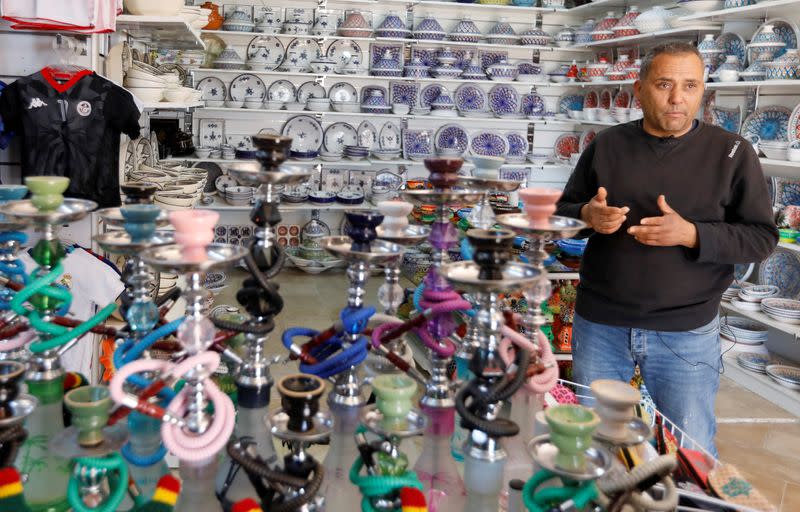 Shop owner Ammar Jouini speaks during an interview with Reuters at his shop in Hammamet