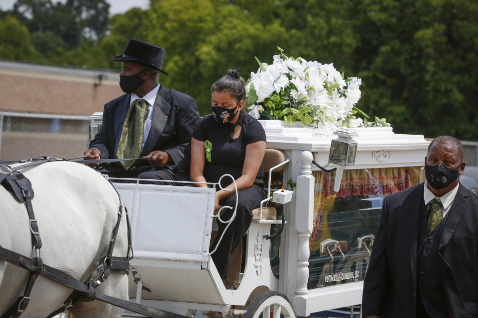 Lupe Guillen, the youngest sister of U.S. Army Specialist Vanessa Guillen rides on a horse draw carriage as they made a final lap around the Cesar Chavez High School track Friday, Aug. 14, 2020, in Houston. Guillen, who was last seen on April 22, was laid to rest nearly four months after she is said to have been killed by a fellow soldier at Fort Hood, a U.S. Army base in Texas. Mourners gathered at the high school where Guillen grew up playing soccer and dreaming of joining the military. (Steve Gonzales/Houston Chronicle via AP)