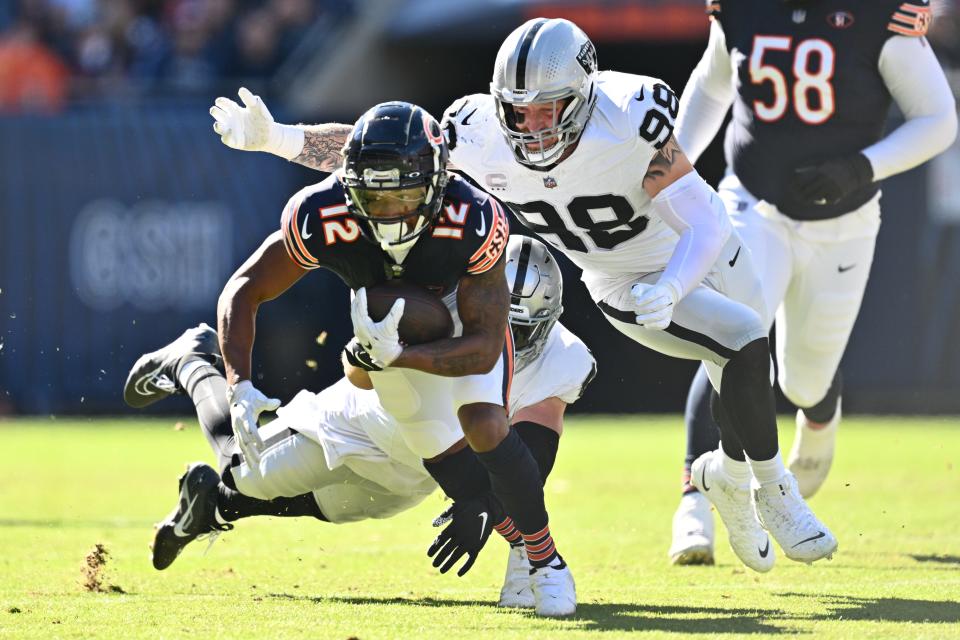 Chicago Bears wide receiver Velus Jones Jr. II (12) is brought down by Las Vegas Raiders defensive end Maxx Crosby (98) and linebacker Robert Spillane (41) at Soldier Field.
