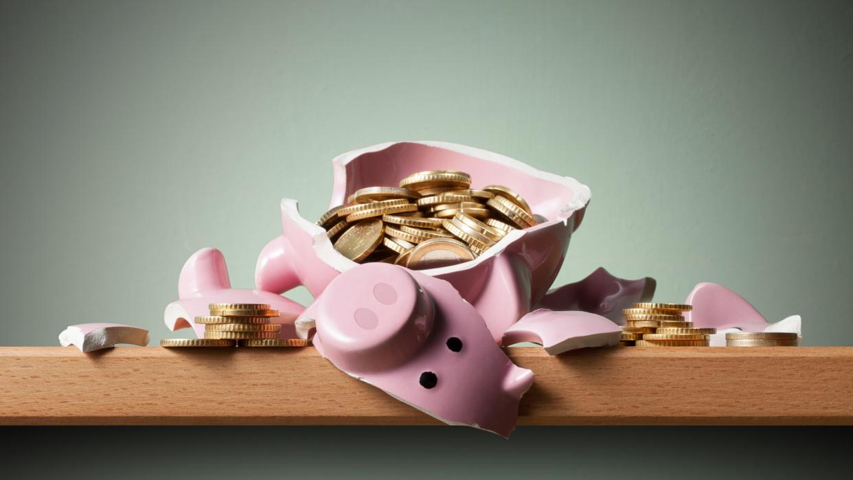 Broken piggy bank with euro coins on the shelf.