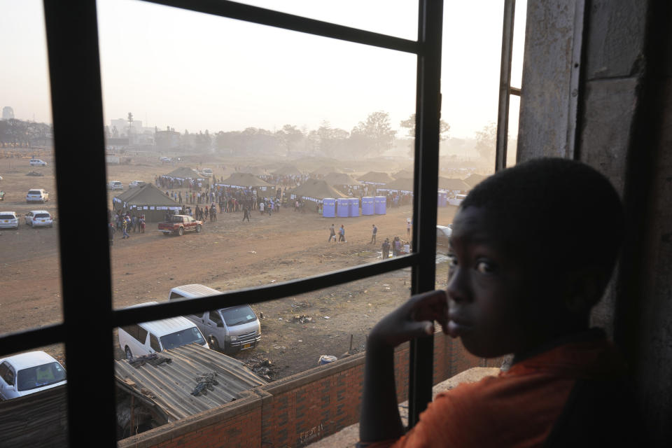 A young boy looks on as a polling station is seen through a window in Harare, Zimbabwe, Wednesday, Aug. 23, 2023. (AP Photo/Tsvangirayi Mukwazhi)