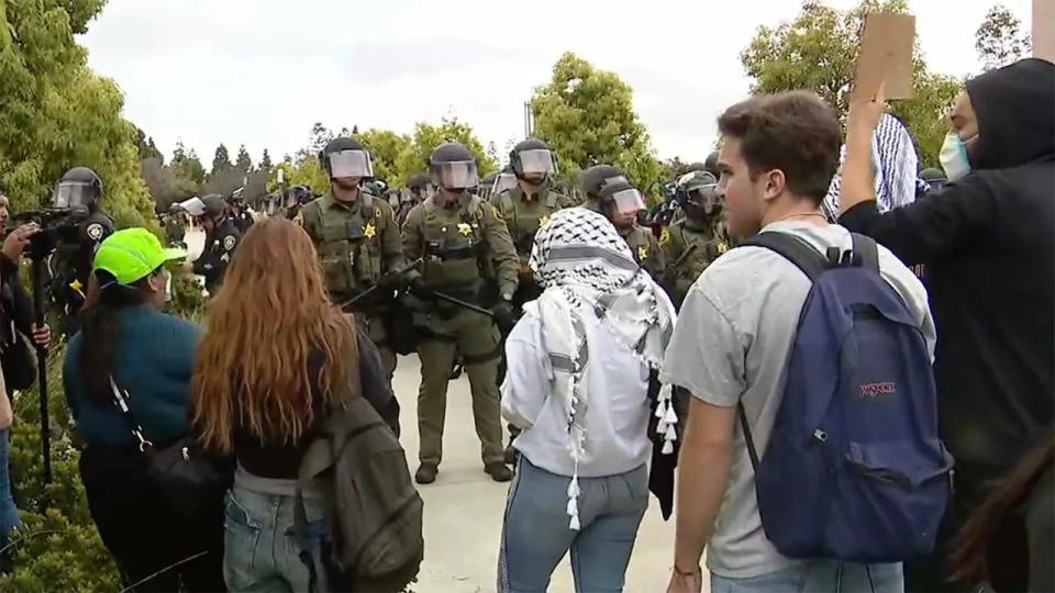 Police stand in front of anti-Israel agitators at the University of California, Irvine, on Wednesday.