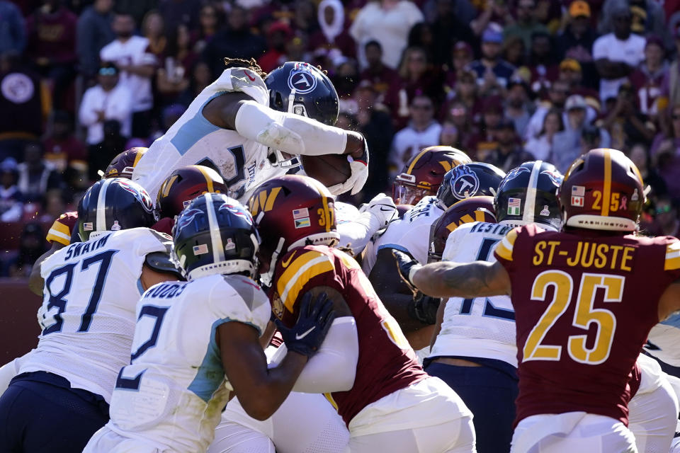 Tennessee Titans running back Derrick Henry, top left, dives into the end zone for a touchdown in the second half of an NFL football game against the Washington Commanders, Sunday, Oct. 9, 2022, in Landover, Md. (AP Photo/Alex Brandon)