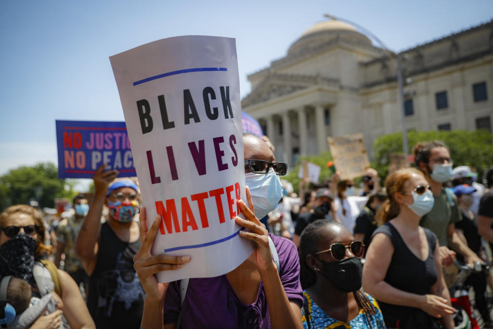 FILE - In this June 19, 2020, file photo, protesters wear protective masks as they march after a Juneteenth rally outside the Brooklyn Museum, in the Brooklyn borough of New York. A loose network of Facebook groups that took root across the country in April to organize protests over coronavirus stay-at-home orders has become a hub of misinformation and conspiracies theories that have pivoted to a variety of new targets. Their latest: Black Lives Matter and the nationwide protests against racial injustice. (AP Photo/John Minchillo