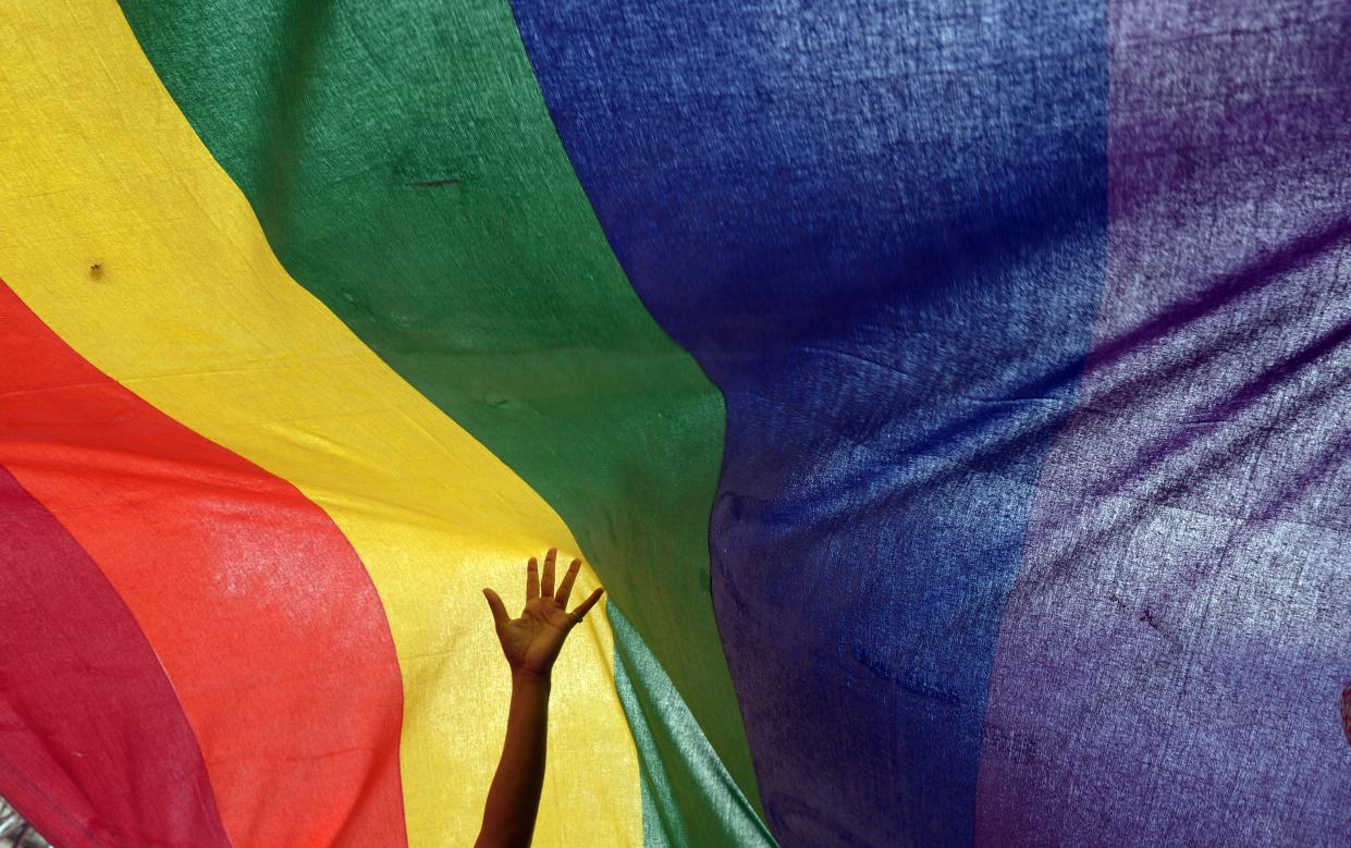 <p>File Image: An Indian sexual minority community member gestures over a rainbow flag while participating in a Rainbow Pride Walk in Kolkata on 7 July 2013</p> (Getty Images)