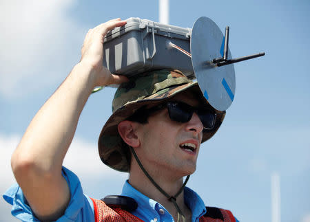 College of Charleston student Sam Fink with the Space Grant Ballooning Project, tests a connection with the mainland before launching a test balloon in preparations for Monday's solar eclipse on board a US Coast Guard response boat at sea near Charleston, South Carolina, U.S. August 17, 2017. Location coordinates for this image are 32º41' 975" N 79º44'195" W. REUTERS/Randall Hill