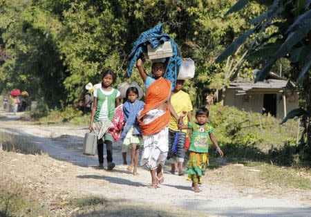 A family carries their belongings as they move to a safer place after ethnic clashes in Tenganala village, in Sonitpur district in the northeastern Indian state of Assam December 24, 2014. REUTERS/Stringer