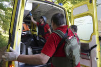 Medical workers load a body of a man killed during shelling in a yard of an apartment building in Kharkiv, Ukraine, Monday, June 27, 2022. (AP Photo/Andrii Marienko)