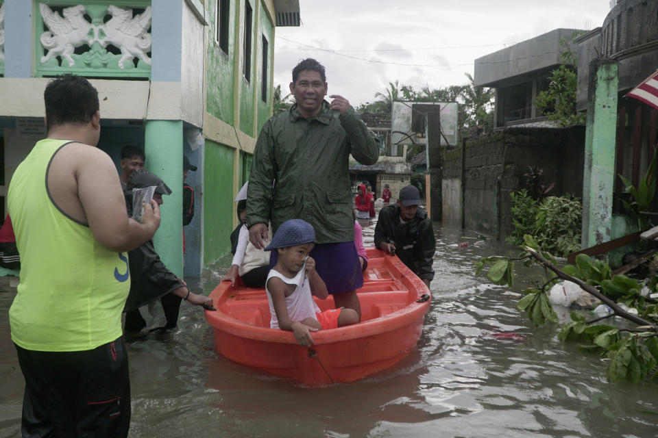 Residents ride a boat along a flooded village as typhoon Vongfong passes by Sorsogon province, northeastern Philippines on Friday May 15, 2020. More than 150,000 people were riding out a weakening typhoon in emergency shelters in the Philippines on Friday after a mass evacuation that was complicated and slowed by the coronavirus. (AP Photo/Melchor Hilotin)