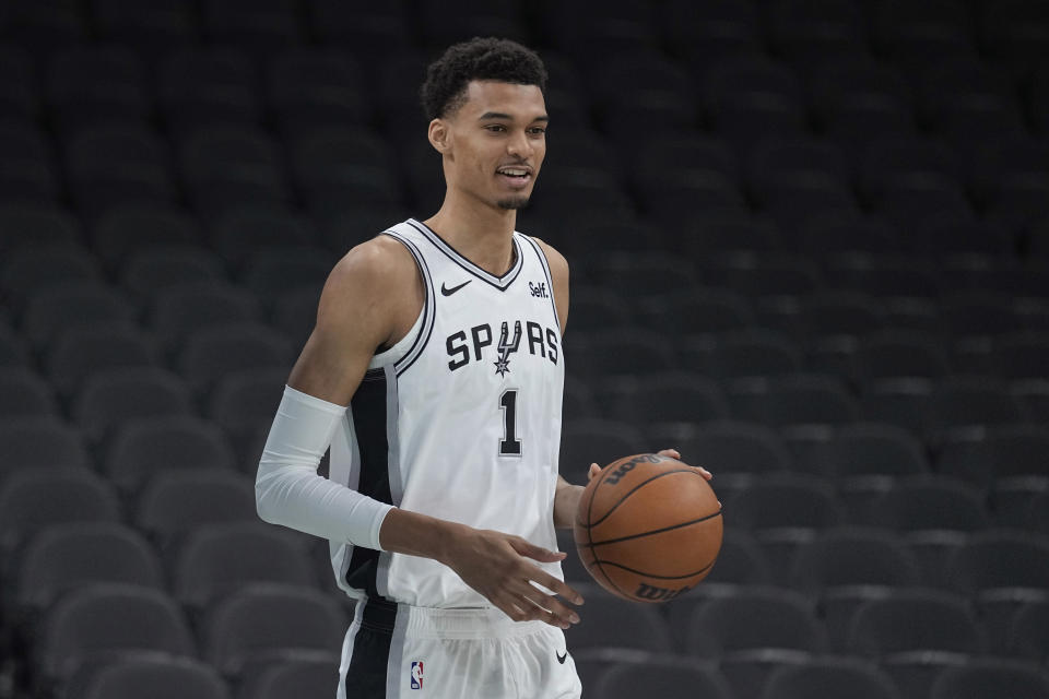 CORRECTS BYLINE TO Eric Gay - San Antonio Spurs' Victor Wembanyama, the No. 1 draft pick, handles a ball during an NBA basketball press conference, Saturday, June 24, 2023, at the AT&T Center in San Antonio. (AP Photo/Eric Gay)