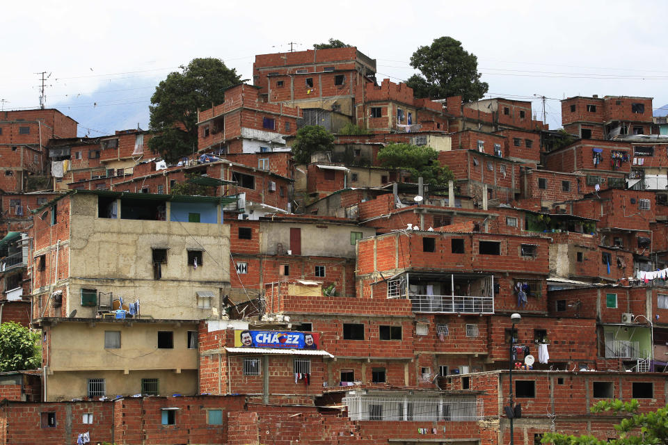 In this Sept. 11, 2012 photo, a lone campaign poster of Venezuela's President Hugo Chavez hangs from a cinderblock home in the Petare shantytown of Caracas, Venezuela. From single mothers to construction workers, a segment of Chavez supporters have been turning away from the president and instead considering new leadership. They've become key to the Oct. 7 presidential vote and opposition candidate Henrique Capriles' strategy. (AP Photo/Fernando Llano)