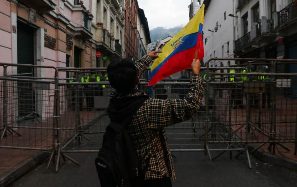 Un manifestante carga una bandera mientras se manifiesta en Quito, Ecuador.