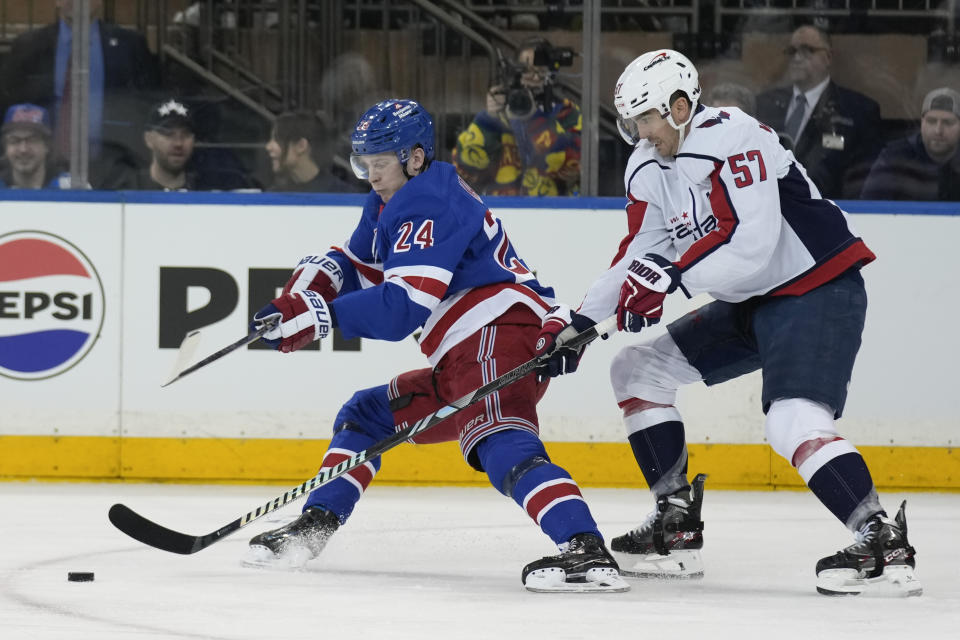 New York Rangers' Kaapo Kakko, left, and Washington Capitals' Trevor van Riemsdyk, right, compete for the puck during the first period in Game 1 of an NHL hockey Stanley Cup first-round playoff series, Sunday, April 21, 2024, in New York. (AP Photo/Seth Wenig)