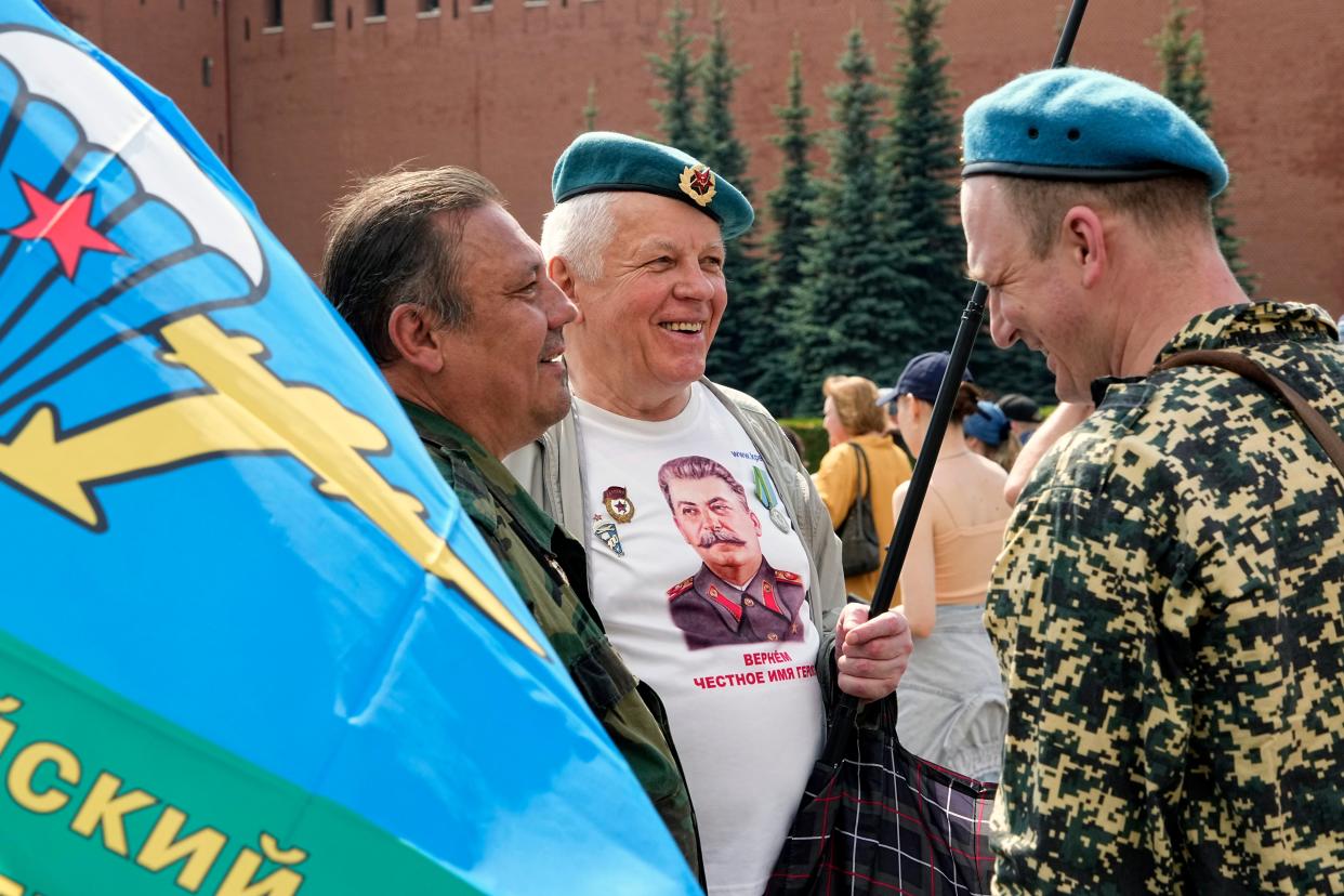 Russian veterans paratroopers, one of them wearing a t-shirt with the image of Soviet leader Josef Stalin, talk to each other during celebrations on Paratroopers Day and Saint Prophet Iliya's Day on Red Square in Moscow (AP)