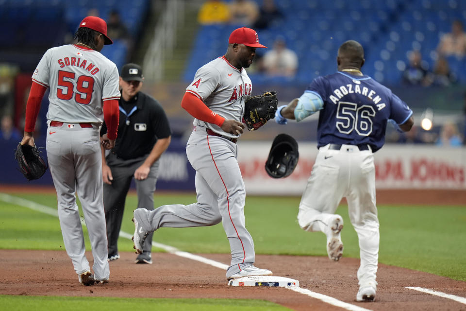 Los Angeles Angels first baseman Miguel Sano, center, beats Tampa Bay Rays' Randy Arozarena (56) to the bag after a ground ball during the first inning of a baseball game Tuesday, April 16, 2024, in St. Petersburg, Fla. Looking on is pitcher Jose Soriano (59). (AP Photo/Chris O'Meara)