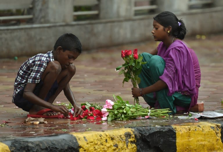 <p>Indian girl children sort through roses for sale during rain showers in Mumbai on June 28, 2016. Annual monsoon rains have progressed to most parts of western and central India, easing fears of millions of desperate farmers after two straight years of drought, the weather department said. </p>