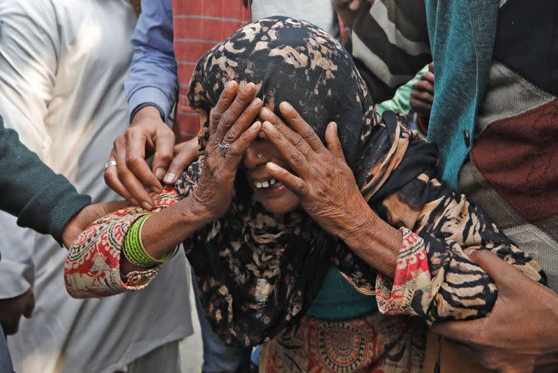 A woman cries as she waits outside a mortuary to receive the body of her relative who died in a fire that swept through a factory where labourers were sleeping on Sunday, in New Delh