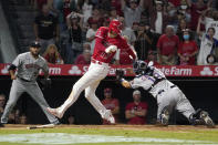 Los Angeles Angels designated hitter Shohei Ohtani, center, avoids a tag by Houston Astros catcher Jason Castro, right, but misses the plate as relief pitcher Yimi Garcia watches during the 10th inning of a baseball game Wednesday, Sept. 22, 2021, in Anaheim, Calif. Ohtani was later tagged out by Castro. (AP Photo/Mark J. Terrill)