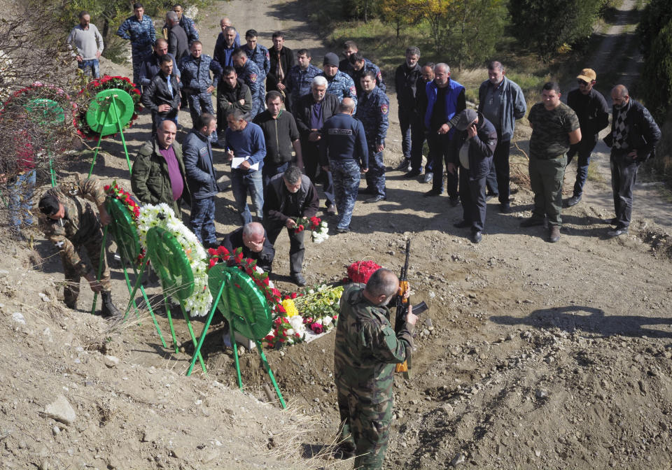 People bury their relative and friend killed during a military conflict, at a cemetery in Stepanakert, the separatist region of Nagorno-Karabakh, Sunday, Oct. 18, 2020. Armenia and Azerbaijan are trading accusations of violating the new cease-fire in their conflict over the separatist Nagorno-Karabakh territory despite a true announced Saturday that was supposed to take effect at midnight. It is a second attempt to establish a cease-fire in the region since heavy fighting there broke out on Sept. 27. (AP Photo)