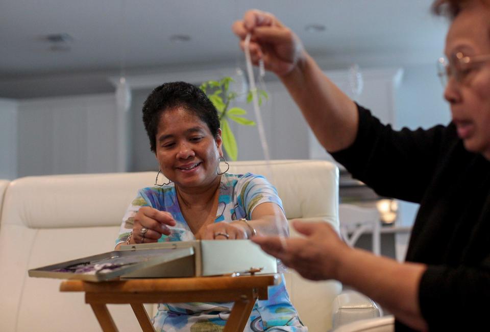 Nisarat "Nungning" Jittasonthi crafts bracelets with her mother, Supee Spindler, at their home in Vero Beach, Tuesday, Nov. 14, 2023. In February of 2021, Vero Beach police and federal agents showed up at the door of Spindler's 12-year-old therapeutic massage and facial business. A woman Spindler described as a disgruntled ex-employee, had reported to police that Jittasonthi might be a victim of human trafficking. No charges were ever filed. Almost two years passed before she found her daughter in poor condition at a Coalition to Abolish Slavery and Trafficking shelter in Los Angeles, with the help of Spindler's attorneys. Today, Jittasonthi is happy to be home.